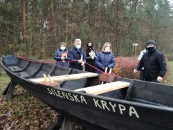 Replika dużej drewnianej łodzi rybackiej i ludzie wokół niej