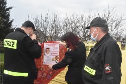 Ludzie zgromadzeni wokół stalowego pojemnika w kształcie serca