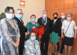 Strasi małżonkowie z kwiatami i medalem