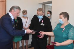 Strasi małżonkowie z kwiatami i medalem