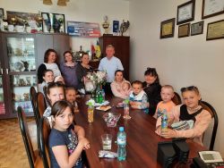 Grupa ludzi w tym dzieci przy stole 01