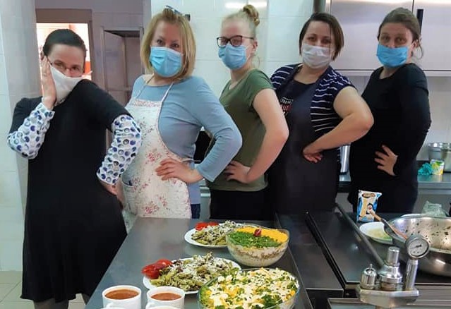 uśmiechnięte, dumne panie przy stole z jedzeniem