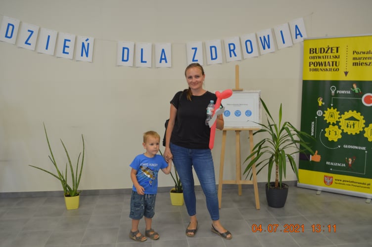 Mama stojąca z dzieckiem na tle napisu dzień dla zdrowia