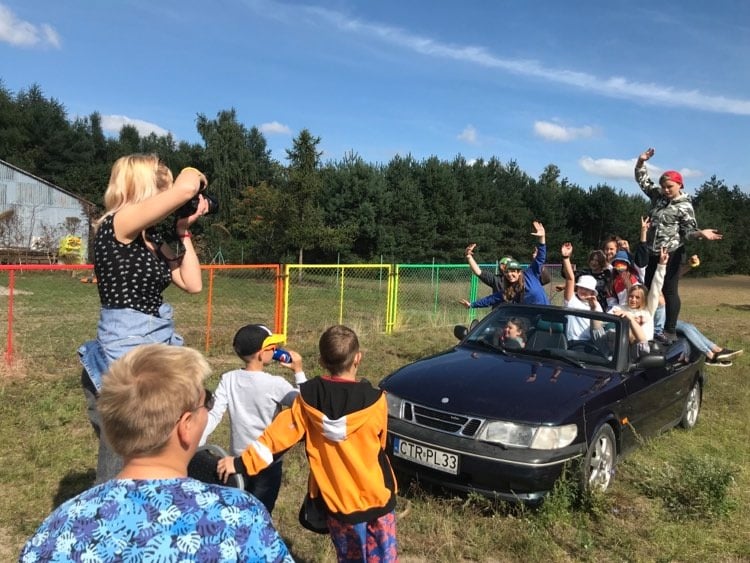 dzieci w samochodzie, kobieta robi im zdjęcie